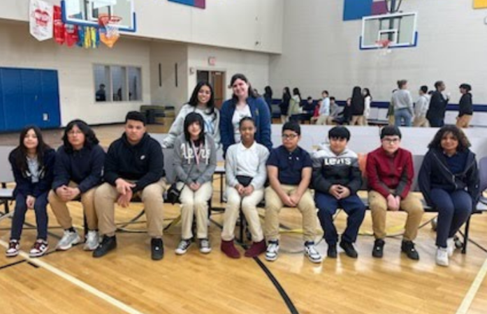  Spelling Bee participants sitting on a bench smiling for a group photo